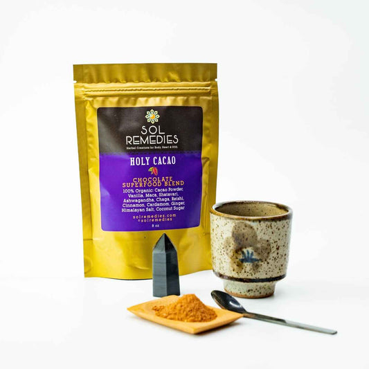 Sol Remedies Holy Cacao. Chocolate superfood blend. Cacao Powder, Ashwagandha, Reishi, Chaga. Powder on small platter with spoon and ceramic cup